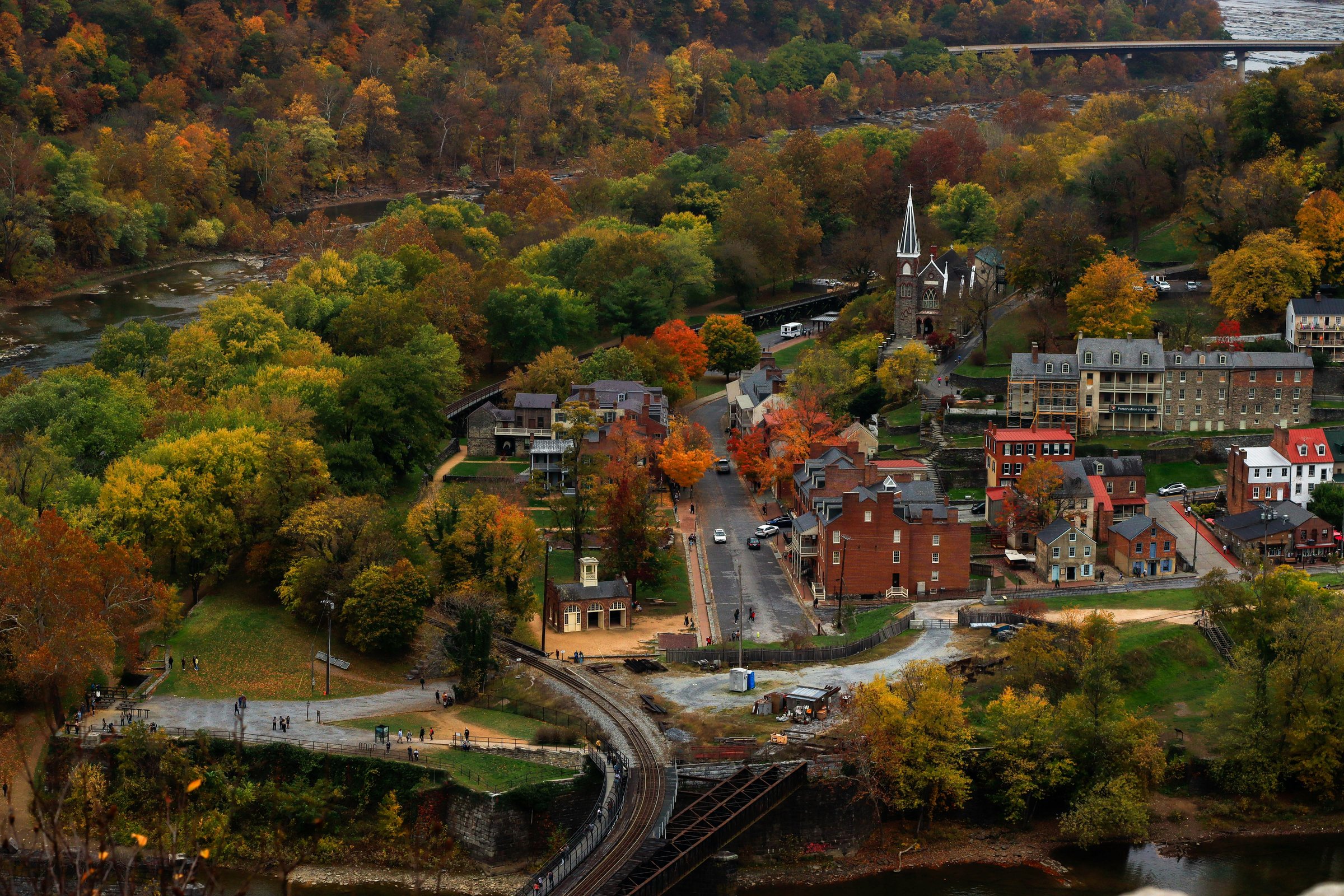 Lower Town Harpers Ferry in fall color, seen from Maryland Heights, with St. Peter’s steeple above the rooftops