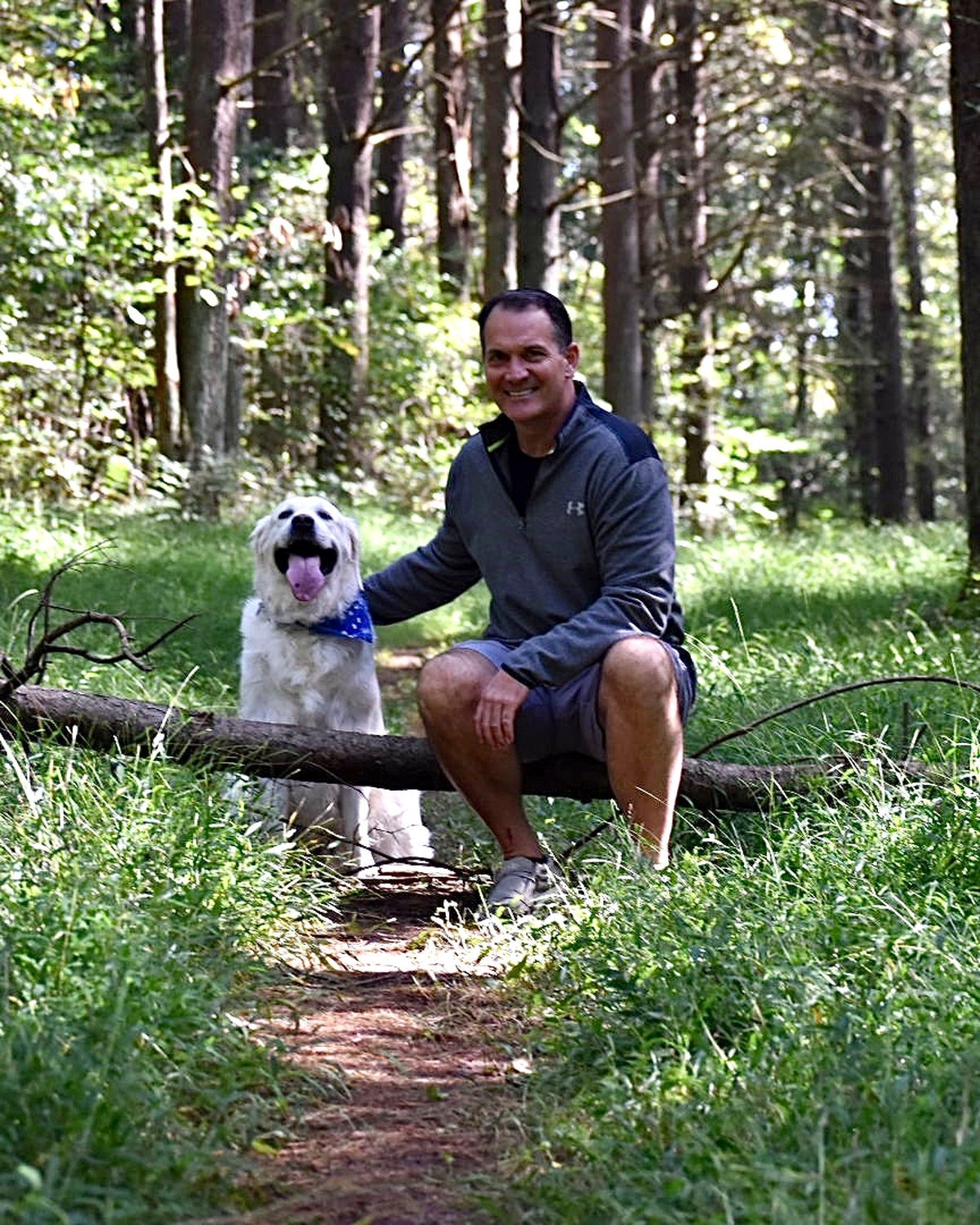 Trey crouched beside Sawyer on a wooded trail